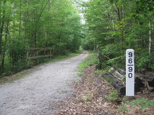 Ed Hiller is restoring the historic bridge markers along the Northern Rail Trail. This one shows that the small bridge just beyond it is 96.90 miles from Boston's North Station when measured along the path of the old rail line. Photo: Ed Hiller