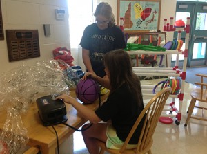 AE/MS eighth grade students have been helping set up for the new school year. Chloe Methven and Betsy Abrahamson are shown inflating basketballs and stocking the playground cart. Photo: Jane Slayton