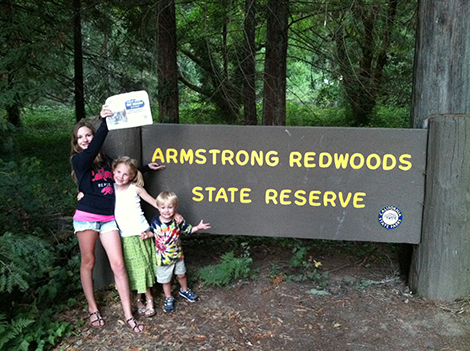 The Armstrong kids - Scout, Helen, and Patch - are pictured here in Northern California reading the Beacon while checking on the family redwood grove. Photo and caption: Kent Armstrong