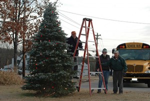 Andover Lions Club members Jim Goody, Tim Norris, and Howard George put the finishing touches on the town's Christmas tree. The public is invited to the annual lighting ceremony on Sunday, December 1, at 5 PM with refreshments in the Town Hall after the lighting. Photo: Charlie Darling