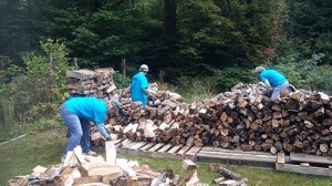At one project, Jen Ellis of Elkins and Nancy Teach and Marcia Emery, both of Andover, stacked many cords of firewood. Photo: Sue Johnson