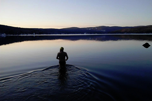 Jesse Schust heads out for a late-day swim on Pleasant Lake over Thanksgiving weekend 2015, after a fresh snow. The water temperature was estimated at 45 degrees. Jesse will speak on April 8 in Danbury about his winter-swimming hobby. Photo: Jesse Lambert