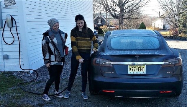 Headed home to New Jersey for Thanksgiving break, Proctor Academy junior Paloma Croghan, right, and her mother Emma-Kate, recharge their all-electric Tesla Model S at the Highland Lake Inn in Andover, the town's only Tesla charging station. Caption and photo: Larry Chase