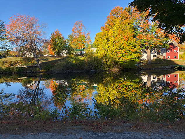 A Red Barn Competes With The Colorful Foliage Around Highland Lake