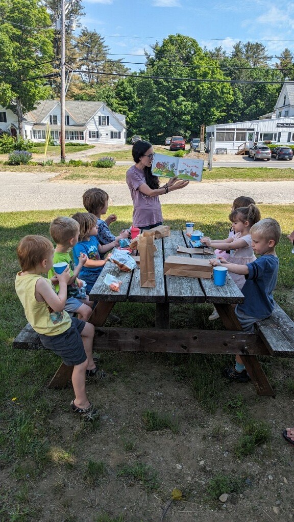 Children Enjoy Healthful Snacks while Reading Outside